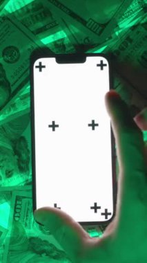 Dikey video. Boş Beyaz Ekran Modelleri ve İzleme İşaretleri ile Smartphone 'a, 100 Dolarlık Parlak Özgeçmişin Üzerine Yerleştirilmiş, Etkileşimli Teknolojinin Vurgulanması