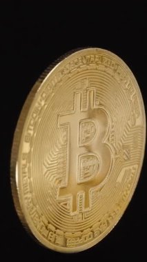 Dikey video. Altın Bitcoin madeni Para, sürekli Kara Arkaplan Karşısındaki Kusursuz Döngü 'de dönüyor. Yumuşak Döndürme İşlemeleri ve Devre Ayrıntılarını Vurguluyor