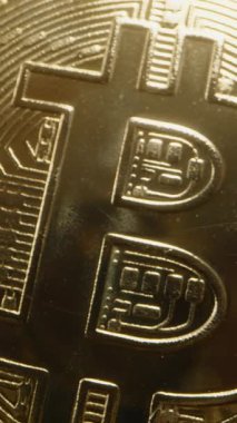 Dikey video. Bitcoin madeni para karanlık kayalardan sarkıyor, madencilik kavramını vurguluyor. Cilalı Yüzey İnce Işığı Yansıtır, Şifrelemeyi Altın İçin Dijital Değiştirme Olarak Temsil Eder