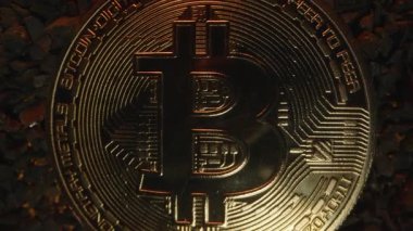Bitcoin Bozukluklarının Yakın Çekimi Karanlık Çakıl 'ın Ortasında Yavaşça Uzaklaşırken, Ilık Işıldayan Işık ve Dramatik Bir Perspektif Değişikliği Oluşturan Kamera