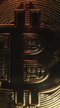 Dikey video. Bitcoin Bozukluklarının Yakın Çekimi Karanlık Çakıl 'ın Ortasında Yavaşça Uzaklaşırken, Ilık Işıldayan Işık ve Dramatik Bir Perspektif Değişikliği Oluşturan Kamera