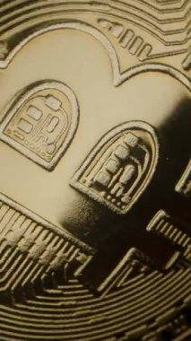Dikey video. Bitcoin Coin Dönüyor ve Yavaş yavaş Kara Arkaplana Karşı Düşüyor, Kabartma Ayrıntılarını Vurguluyor, Piyasa Azalmasını ve Mali İstikrarsızlığı Temsil Ediyor. Yavaş çekim
