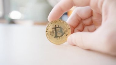 Side View 'dan Parlak Arkaplan Görüntü' sü olan açık ahşap bir masa üzerinde Bitcoin Para Tutmak. Şifreleme Değeri ve Modern Dijital Finans kavramı