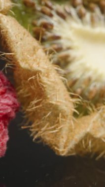 Dikey video. Kurutulmuş meyveler ve meyveler Yansıtıcı bir Siyah Yüzeye yerleştirildi. İçinde Buruşuk Kiraz, Kurutulmuş Kivi ve Tohumlu Dokulu Çilek var. Yaşlanma ve Kurutma Sürecine odaklan. Dolly kaydırıcı, kapat.