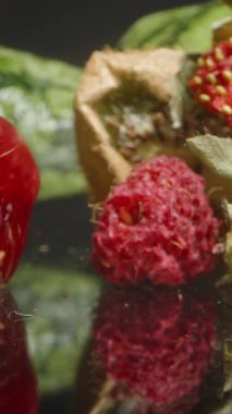 Dikey video. Yansıtıcı yüzeyinde kurutulmuş çilek ve susuz kivi ile buruşmuş kırmızı kiraz tutuyorum. Meyve Dokusuna ve Yaşlanma Detaylarına Odaklan