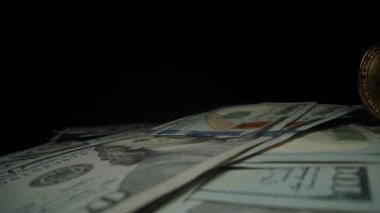 ABD Dolarları Yığını Üzerinde Dramatik Işıklandırmayla Karanlıktan Çıkan Altın Bitcoin Para. Kripto Para Biriminin Yükselişini ve Modern Finans Değerini Sembolize Ediyor