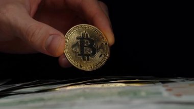 Çıplak El Karanlık Bir Arkaplana Karşı Bir ABD Doları Yığını Üzerine Parlak Bitcoin Tutuyor. Modern Finans 'ta Kripto Para Birimleri Rolünü Sembolize Etmek