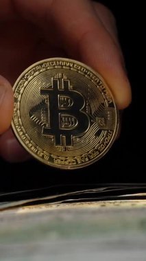 Dikey video Çıplak El, Modern Finans 'ta Şifreleme Rolüne Karşı ABD Doları Fatura Yığını Üzerine Parlak Para Tutuyor