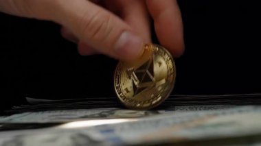 Geleneksel Para ve Şifreleme Para Birliğinin Birleştirilmesini Sembolize eden 100 Dolarlık ABD Doları Yığının Yanında Altın Ethereum Madeni Para Tutmak
