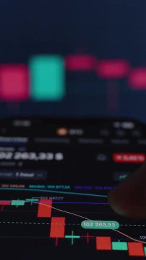 Dikey video. Bitcoin Ticaret Uygulamasını Yeşil ve Kırmızı Şamdanlarla Gösteren Akıllı Telefon, Finansal Piyasa Eğilimleri ve Kripto Para Çizelgeleri 'nin bulanık geçmişine Karşı El Tutma Aygıtı,