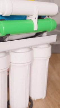 Dikey video. Eller Osmosis Sistemi 'nin Filtre Konutlandırma Ampulünü sökmek için Bir Anahtarı Kullanıyor, Bakım Sürecinin bir parçası olarak İçerideki Filtreyi Değiştirmeye Hazırlanıyor
