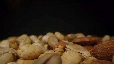 Karanlık Bir Arkaplana Karşı Yavaş Çekimde Düşen Karışık Fındıkların Yakın Çekim Görünümü Hareketi ve Dokusunu Vurguluyor. Sağlıklı atıştırmalıklar veya organik gıdalar