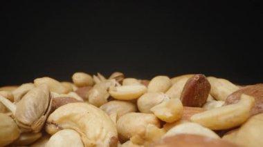 Kaypak Hareketli Karışık Ceviz Yığını Karanlık Bir Arkaplana Karşı Yakından Bakış, Doku ve Doğal Renkleri Vurguluyor. Konsept: Besleyici Gıda veya Atıştırma Çeşitliliği