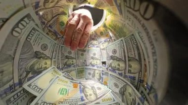 Bir El Yığından 100 Dolarlık Faturaları Alırken Bir Kavanozun İçinden Yakından Bakış Nakit Çekme Eylemini Vurguluyor. Yoksunluk ve Mali Kullanım Yasası