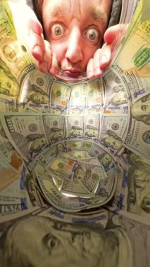 Dikey video. Yüz Dolarlık banknotlarla dolu bir kavanozun içinden geniş gözlerle bakan bir adam olarak dramatik ve oyuncu bir zenginlik gözlemi ifadesi yaratıyor. Merak ve Zenginlik Arasında Bağlantı