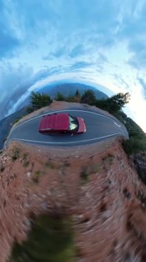 Dikey video. Kıvrımlı Dağ Yolu 'ndaki Kırmızı Araba Hava Görüntüsü Alacakaranlık Gökyüzü ve Orman Ufku ile Küresel Bakış Alanında Yakalandı. Benzersiz Sahne Sürücüsü