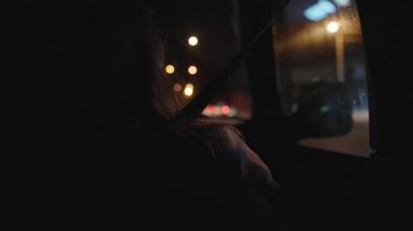 Arka Koltuktan Gece Araba Görünümü, Arka Pencereden Sokak Işıkları ve Yansımaları Gösterilen Çerçevede Yolcu Silueti ve Emniyet kemeri ile. Gece Yolculuğu