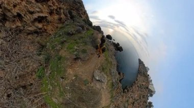 Bir Dar Kayalıklarda Dar Kayalık Patikada Yürüyen Erkek ve Kadın Gezgin Altında Büyük Okyanusu Gösteren Küçük Bir Gezegen Efektiyle Yakalandı. Sahne Kıyı Yolculuğu