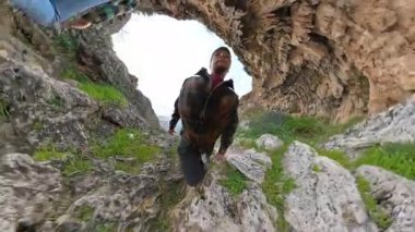 Ekose ceketli bir adam mağara açılışı yakınlarındaki Rocky Trail 'e tırmanıyor, çarpık küresel perspektifte yakalandı, kadın önümüzde yürüyor. Macera Yürüyüşü