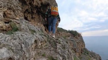 Sarı Sırt Sırtında Yürüyen Kadın Kayalık Yol 'da Denize Bakan Adam' la Önplan 'da Kısmen Görünür. Kıyı Seyahati