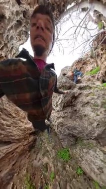 Dikey video. Eşsiz Kaya Dokularıyla Dik Uçuruma Tırmanan Adam, Gözden Geçiren Deniz Küresel Bakış Açısı Saptıran ve Etkileyici Etki Yaratan Adam. Aşırı Tırmanma