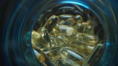 Jelatin kapsül ve tabletlerle dolu, Mavi Balık yağı ve vitamin kavanozlarıyla çevrili çoklu açık mavi kapsüller, Vibrant Macro View