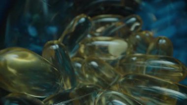 Altın Jelatin Kapsülleri ve Beyaz Tabletler içeren Açık Mavi Gözlerin Çeşitliliği, Mavi Vitamin Şişeleri ve Karanlık Bir Arkaplanda İlaveler