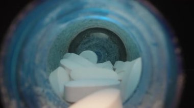 El Arkaplanda Mavi İlave Şişeli Açık Mavi Lid 'den Tek Bir Beyaz Tablet Seçme, Dolly kaydırma, kapat.