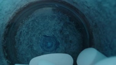 Beyaz Oval Tabletler Mavi Şişe 'den Açık El' e dökülüyor. Pürüzsüz yüzeylerini ve Temiz Görünümlerini Vurguluyorlar. Günlük Beslenme Kaydıracı, kapat..