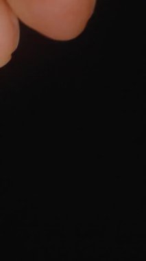 Dikey video. El Tutma Üç Altın Şeffaf Omega 3 Kapsülleri Parlak Yüzeylerini ve Yumuşak Doku Eklentilerini Vurguluyor