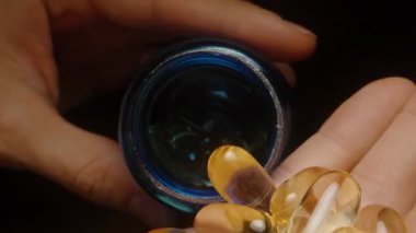 Altın Şeffaf Omega 3 Kapsülleri Mavi Kavanozdan Parlak Yüzeyi ve Canlı Renkli Beslenme Eklentilerini Vurguluyor