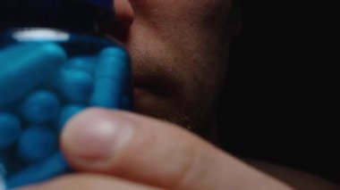 Mavi Kapsül Şişesi Tutan Bir Adamın Yakın Çekimi Canlı Renklerini ve Parlak Doku Sağlığını ve Sağlık Bakımını Vurguluyor