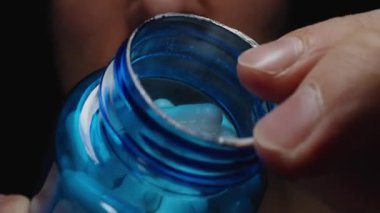 Açık Mavi Şişe 'den Beyaz Kapsül Seçen Bir Adam Pürüzsüz Yüzeyi ve Besleyici İlacın Hassas Şeklini Gösteriyor