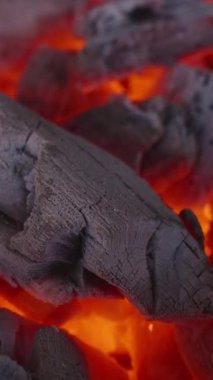 Dikey video. Yanan Kömürün Yakın Çekimi Rüzgârın Yoğunlaştırdığı, Çatlak Dokuyu Gösteren Turuncu ve Kırmızı Sıcaklık ve Kıvılcımların Yükselişi