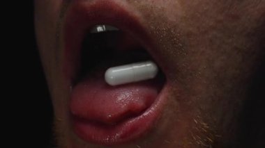 Tablet yutmak için su içen bir adamın yakın çekimi, sonra yutulduğunu göstermek için ağzını açmak, sakallı, sakallı, kenar açılı ağız, dil ve çeneye odaklanmak.