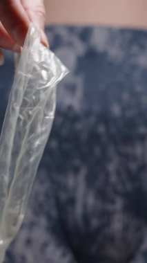 Dikey video. Kameranın Önünde Spermle Dolu Kullanılmış Prezervatif Tutan Bir Kadın Sorumluluğunu Vurguluyor ve Güvenli Seks Uygulamalarını Vurguluyor