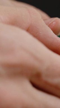 Dikey video. Eller dikkatle bir prezervatifi ambalajından çıkartıyor, Hazırlıyor ve Güvenli Seks Uygulamalarının Önemi Vurguluyor