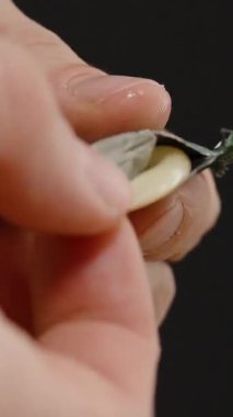 Dikey video. Eller bir prezervatifi tutar ve dikkatlice paketten çıkarır, Güvenli ve Sorumlu Kullanıma Hazırlık