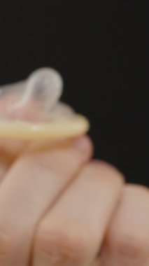 Dikey video. Siyah Arkaplan, Uygun Kullanım ve Kullanım Tekniklerine Karşı Bir Gösterge olarak Kondom Giyen Bir Parmak