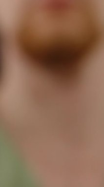 Dikey video. Siyah Arkaplan 'a Karşı Uzatılmış El' de Kondom Tutan Bir Adam Nesneye Odaklanarak Kullandığını Gösteriyor