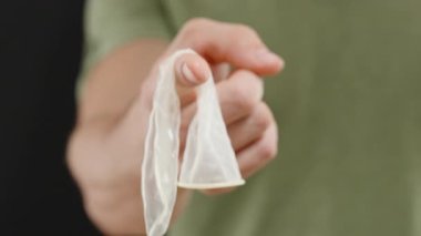 Kullanılmış Prezervatifi Açık Ucuyla Tutan Bir Adam Hijyen ve Sorumlu İmha İşlerini Vurguluyor. Güvenli Seks ve İmha