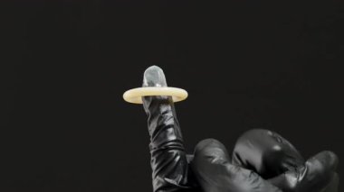 Siyah Eldivenli Bir El Kullanılmış Kondomu Çimdikliyor ve Denetiyor, Uygun Tutma ve Güvenliği Gösteriyor