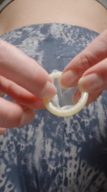 Dikey video. Eğitimsel amaçlar için bir objeye prezervatif takma, doğru tekniği gösterme ve güvenli seks kavramını geliştirme sürecini gösteren yakın plan görüntüler.