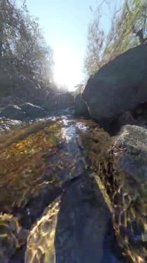 Dikey video. Kayaların Üzerindeki Küçük Şelalenin Güneş Işığı Altından Yansımalar Yaratan Yakından Bakış Geniş Açı Bakış Açısı ile Yakından Görünüşü