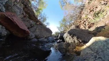 Berrak Gökyüzü ve Güneş Işığıyla Rocky Dağları 'ndaki Küçük Şelalenin Delik Etkisi