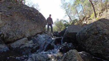 Özenle Yürüyen Adam Arkaplanda Güneş Işığı ve Ormanla Küçük Dağ Kayalıklarında Yürüyor