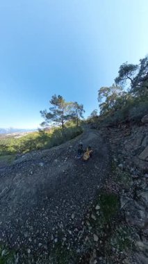 Dikey video. İki Gezgin Rocky Dağları 'nda Yeşil Vadilerin Panoramik Manzarası, Bir Sahil Kasabası ve Yüksek Tepeler