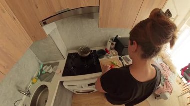 Modern Kitchen 'da Tahta Kesme Kurulu' nda Kahverengi Saçlı Kadın Kırmızılı ve Yeşil Sebzeli Kadın Çarpık Bakış Açısı
