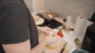 Modern Kitchen 'da Ahşap Kesme Tahtasının Üzerinde Fırın ve İçindekilerle Kaynamış Yumurta Sobası Söndüren Siyah Tişörtlü Kadın