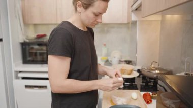 Siyah Tişörtlü Kadın Modern Kitchen 'da Fırın ve İçindekilerle Kaynamış Yumurta Kabuğundan Çıkarıyordu.